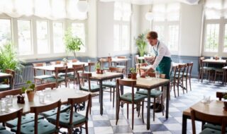 Worker cleaning up a table at a restaurant