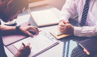 Customer signing loan contract in front of banker