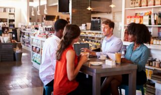 Business Group Having Informal Meeting In Cafe