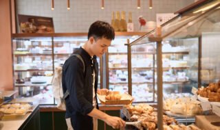 Handsome asian man choosing bakery in store