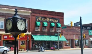 Photo of many brick buildings with colorful storefronts during the day that represent main street America