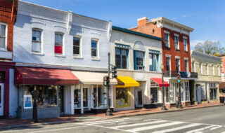 Photo of many brick buildings with colorful storefronts during the day that represent main street America