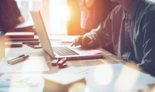 Project meeting. Marketing team discussing new working plan. Laptop and paperwork in open space office